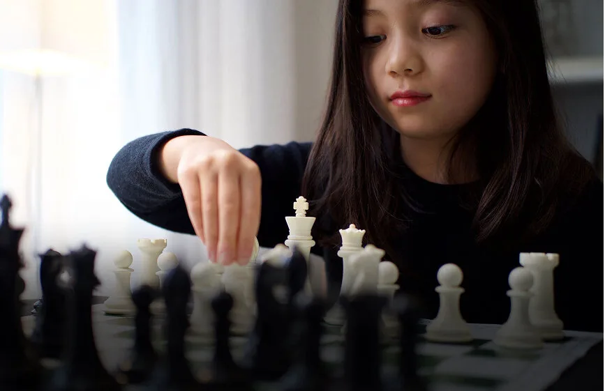 A young chess player considering her next move